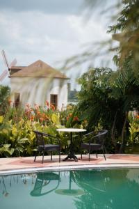 a pool with two chairs and a table and a fountain at Narwar Lakefront Resort in Shivpurī