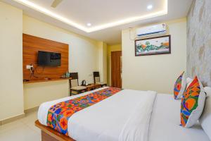 a hotel room with a bed and a television at FabHotel Partha Residency - Kr puram in Bangalore
