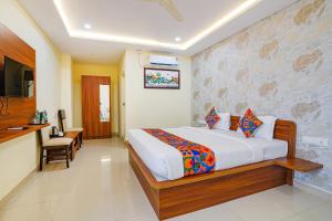 a bedroom with a bed and a television in it at FabHotel Partha Residency - Kr puram in Bangalore