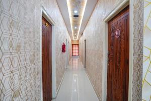 a hallway with wooden doors and tile walls at FabHotel Partha Residency - Kr puram in Bangalore +35 photos