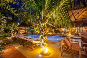 Un restaurante con una mesa y una palmera junto a una piscina. en Maison de clara, en Ngaparou