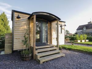 a tiny house with stairs leading to a door at Beech in Kemble