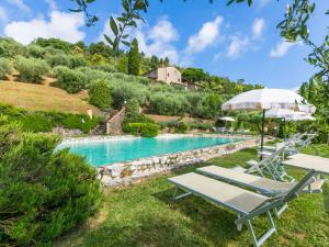 una piscina con dos tumbonas y una sombrilla en Apartment La Cupola- Lavanda by Interhome, en Pescia