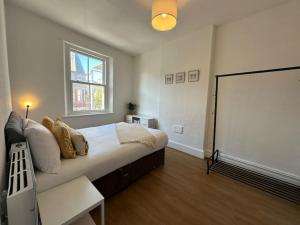 ein Schlafzimmer mit großem Bett und Fenster in der Unterkunft Central Colwyn Bay 2nd Floor Flat 3 in Colwyn Bay