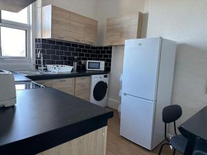 eine Küche mit einem weißen Kühlschrank und einem Geschirrspüler in der Unterkunft Central Colwyn Bay 2nd Floor Flat 3 in Colwyn Bay