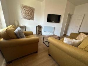 ein Wohnzimmer mit zwei Sofas und einem Flachbildfernseher in der Unterkunft Central Colwyn Bay 2nd Floor Flat 3 in Colwyn Bay