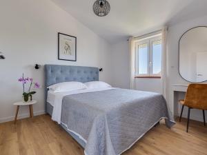 biała sypialnia z łóżkiem i krzesłem w obiekcie Apartment Bonex-7 by Interhome w mieście Privlaka