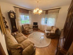 a living room with a couch and chairs and a clock at El Rincón de Oriona in Cedeira