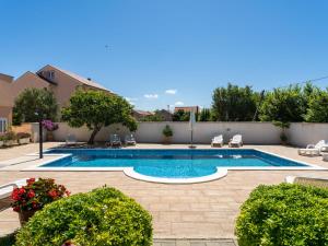 einen Pool in einem Garten mit Stühlen und Pflanzen in der Unterkunft Apartment Bonex-2 by Interhome in Privlaka