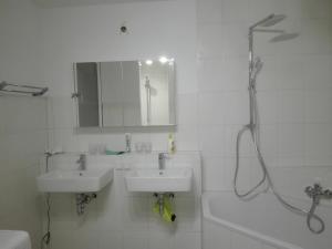 a white bathroom with two sinks and a shower at Messezimmer Hannover / Private rooms for exhibitions in Hannover
