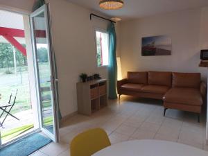 a living room with a couch and a sliding glass door at Apartment Les Jardins de l'Océan by Interhome in Bias
