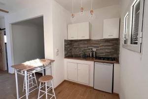 a kitchen with white cabinets and a table and a counter at Casita Del Mar - Beach & Fly in Focene