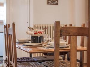 a wooden table with plates and glasses on it at Apartment Genets 150 D by Interhome in Nendaz