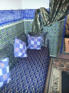 a couch with pillows on it in a room at Riad Dar Kader chambre bleue in Marrakesh