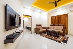 a living room with a flat screen tv and a couch at Hotel Rifaya in Porto Novo