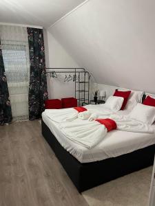 a bedroom with two beds with white and red pillows at Shining Home in Felsőörs
