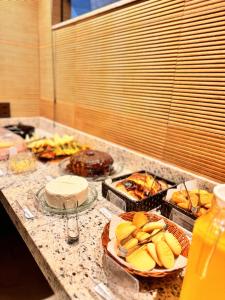 a counter top with plates of food and other foods at Hotel Real Cruzilia in Cruzília