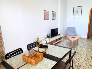 a living room with a table and a tv at Seaside Whale Apartments WIFI 1I in Los Abrigos