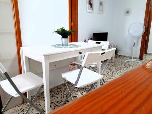 ロス・アブリゴスにあるSeaside Whale Apartments WIFI 1Dの白いテーブルと椅子 +5枚の写真