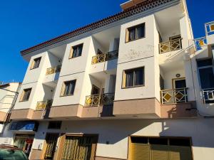 ロス・アブリゴスにあるSeaside Whale Apartments WIFI 1Dの側面にバルコニーがある白い建物