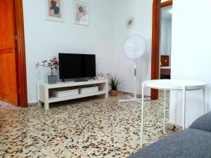 ロス・アブリゴスにあるSeaside Whale Apartments WIFI 1Dのテレビとテーブルのあるリビングルーム