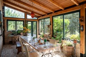 a room with a table and chairs and windows at Villa vacanze floriana in SantʼAngelo in Lizzola