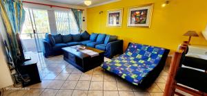 ein Wohnzimmer mit einem blauen Sofa und einem Tisch in der Unterkunft Club Cabana 12 - Sleeps 6 - Perfect Holiday Destination in Margate