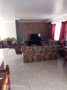 ケープタウンにあるFamily holiday home to rentのソファとテレビのあるリビングルーム