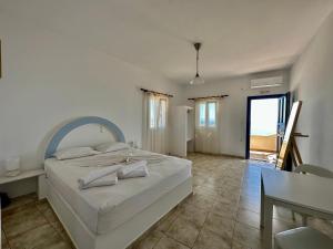 a bedroom with a large bed and a table and chairs at Restía in Donoussa