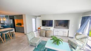 a living room with a tv and a table and chairs at 10 Seaview Close, Shelley Point in St Helena Bay