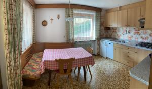 a kitchen with a table and a table and chairs at CIADIN APPART. in Badia +19 photos
