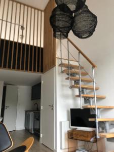 a living room with a spiral staircase in a house at Le trait d'Union le Croisic in Le Croisic +3 photos