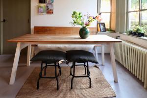 a table with two chairs and a vase with flowers at B&B In het Voorhuys in Zuidlaren
