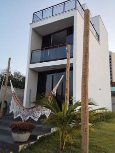 a house with a hammock in front of it at Casa de praia do Zeca in Fortaleza