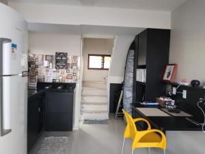 a kitchen with a staircase and a yellow chair at Casa de praia do Zeca in Fortaleza