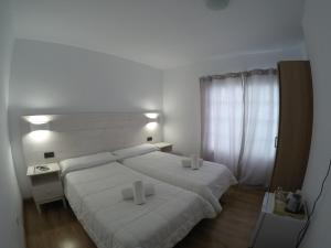 una camera da letto bianca con due letti e una finestra di Villa las Flores ad Adeje Altre 10 foto