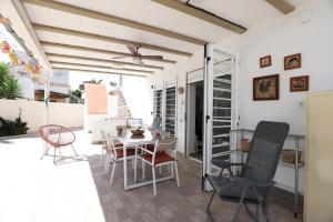 una sala da pranzo con tavolo e sedie su un patio di 2 apartamentos en una excelente villa de playa compartiendo Piscina y Jardín a Sagunto