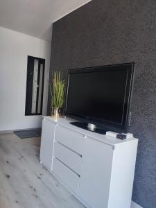 a flat screen tv sitting on top of a white entertainment center at Apartament Lux2 Konin NOCLEGI in Konin