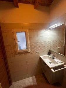 a bathroom with a sink and a mirror and a window at Casa Dafne di Palazzo Biondi in Giarre