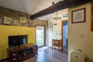 un soggiorno con una TV su una cassettiera in legno di Casa Rural Roi a Portas