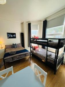 a room with two bunk beds and a table at 10 Minutes to Wembley Guest Studios in London