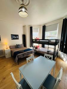 a living room with a table and a bed at 10 Minutes to Wembley Guest Studios in London