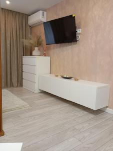 a living room with a white cabinet and a tv on the wall at Apartament General in Galaţi