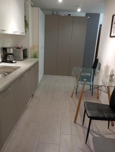 a kitchen with white cabinets and a table and chairs at Apartament General in Galaţi