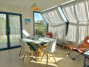 a dining room with a table and chairs at Maison lumineuse La Forêt-Fouesnant proche plage, golf, avec salle de détente et 5 chambres - FR-1-481-158 in La Forêt-Fouesnant