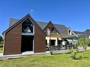 a house with a large window on the front of it at Maison lumineuse La Forêt-Fouesnant proche plage, golf, avec salle de détente et 5 chambres - FR-1-481-158 in La Forêt-Fouesnant
