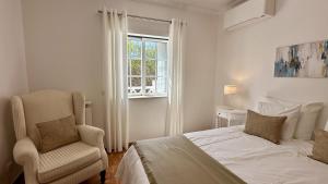 une chambre avec un lit, une chaise et une fenêtre dans l'établissement Pine Cliffs by Check-in Portugal, à Albufeira 26 autres photos