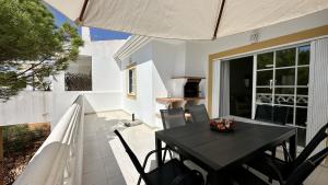 une table noire et des chaises sur une terrasse dans l'établissement Pine Cliffs by Check-in Portugal, à Albufeira