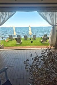 a view of the ocean with chairs and umbrellas at Bambu Urla Otel in Urla +30 photos