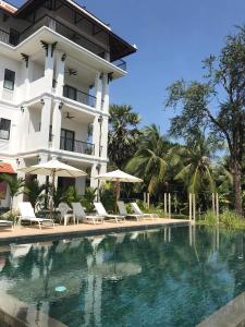 a hotel with a swimming pool in front of a building at Mealy Villa in Phumi Ta Phul